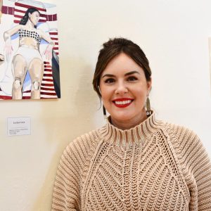 LWC DANI FORD – Lindsey Wilson College art instructor Dani Ford of Jamestown, Kentucky, stands next to “Sunbather,” an acrylic painting on a wood panel that is based on a Polaroid picture taken in the 1970s of Ford’s late grandmother. “Sunbather” is one of the pieces featured in Ford’s show, “Live for Me: A Conversation with Grief,” which is on display through March 3 in the Lucretia C. Begley Gallery in Lindsey Wilson’s W.W. Slider Humanities Center. Ford will give a gallery talk at 2:30 p.m. CT on Tuesday, Feb. 25.